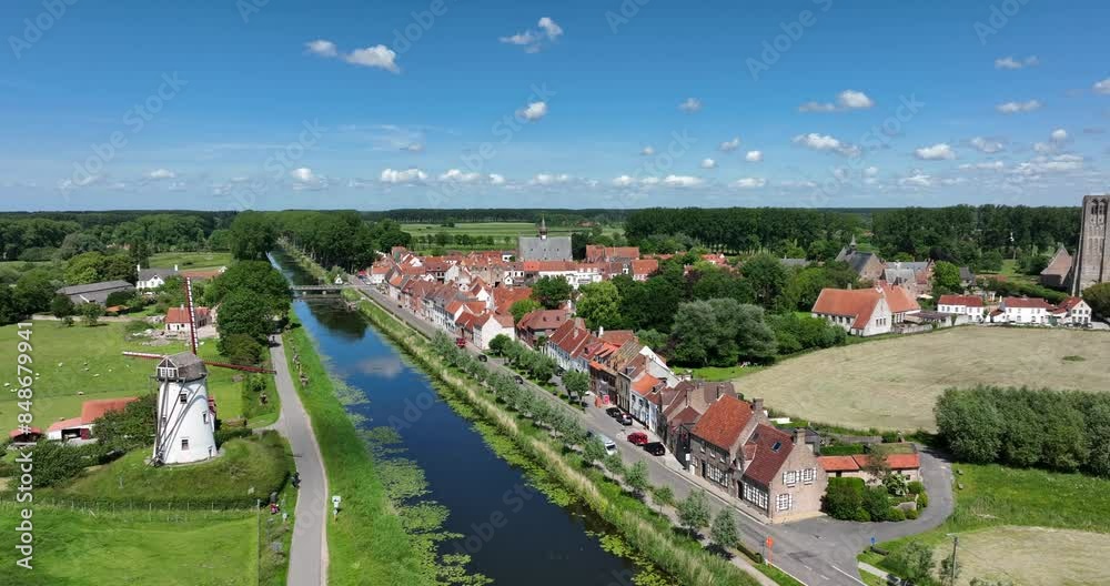 Damme, Belgium, June 2022. Drone orbits away from the Schellemolen windmill towards the town with historic buildings, showcasing the Damse Vaart
canal and lush greenery on a sunny day. Damme, Belgium, June 2022. Drone orbits away from the Schellemolen windmill towards the town with historic buildings, showcasing the Damse Vaart
canal and lush greenery on a sunny day.