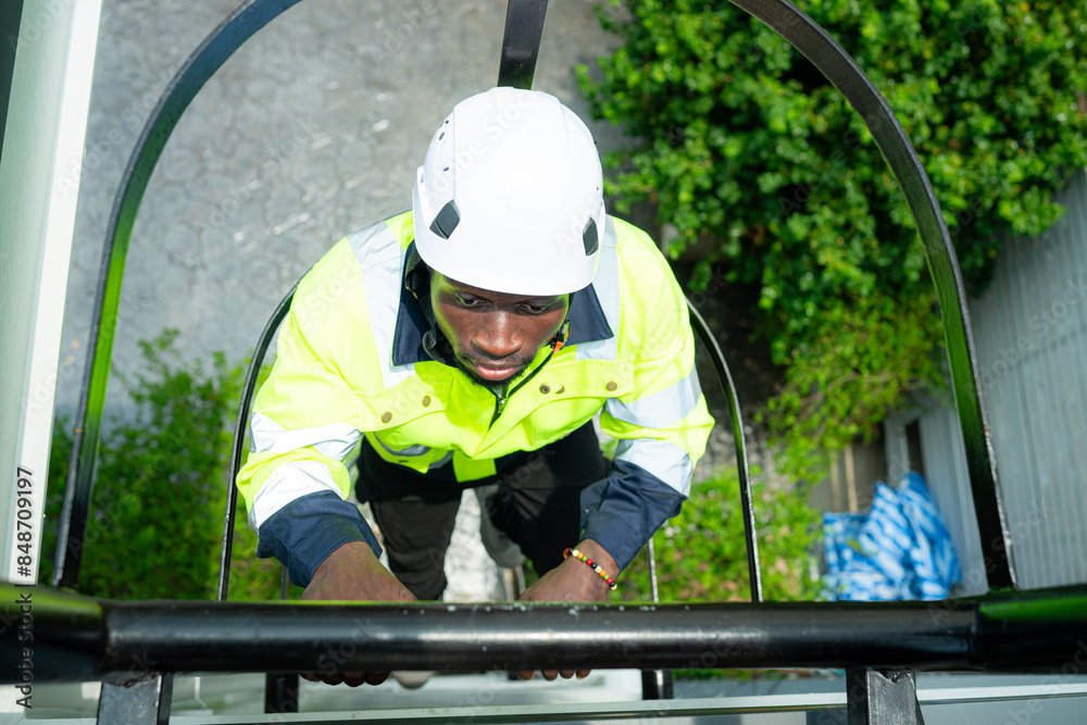 Technician climbs a ladder to the rooftop to check the installation of solar panels Technician climbs a ladder to the rooftop to check the installation of solar panels