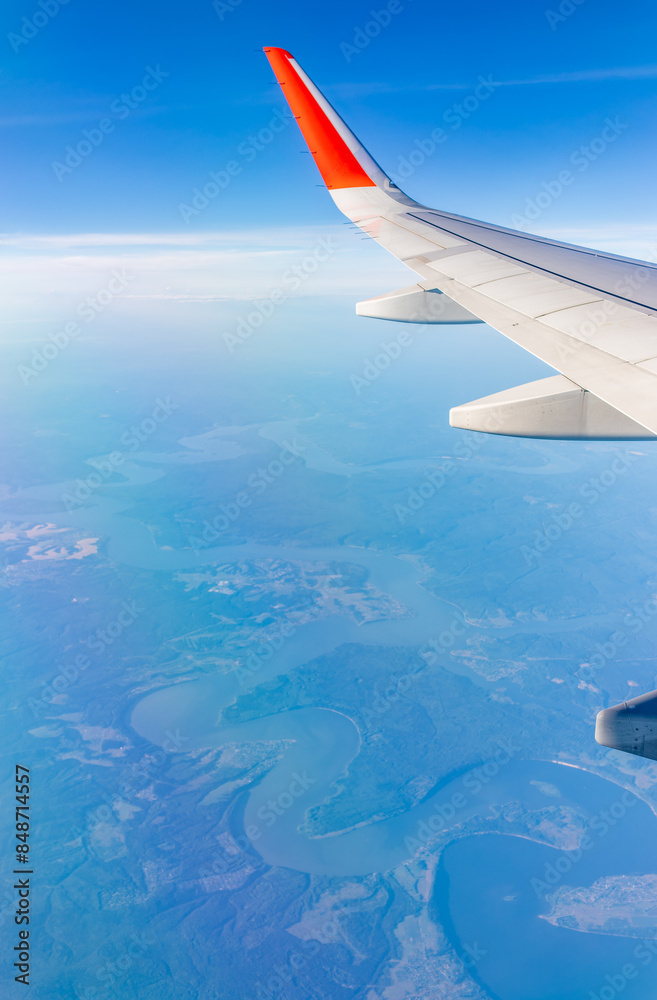 Aerial view from airplane window above green ground. View from the airplane window with beautiful clouds at sunrise Aerial view from airplane window above green ground. View from the airplane window with beautiful clouds at sunrise