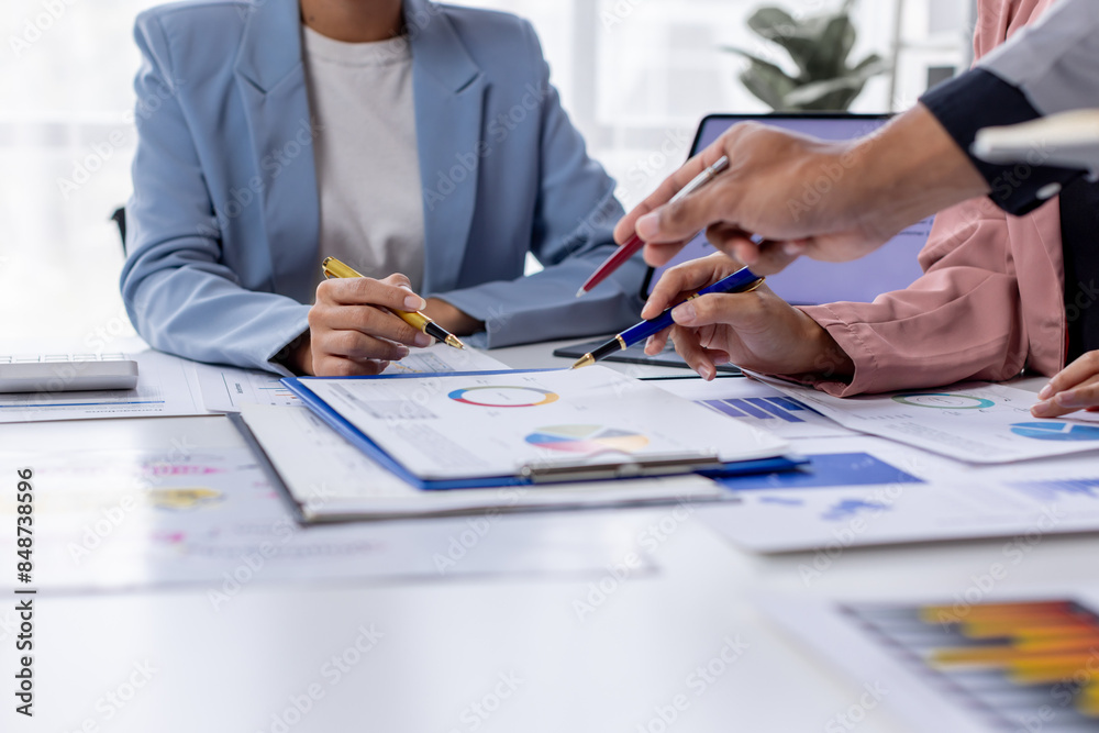Group of confident business people point to graphs and charts to analyze market data, balance sheet, account, net profit to plan new sales strategies to increase production capacity. Group of confident business people point to graphs and charts to analyze market data, balance sheet, account, net profit to plan new sales strategies to increase production capacity.