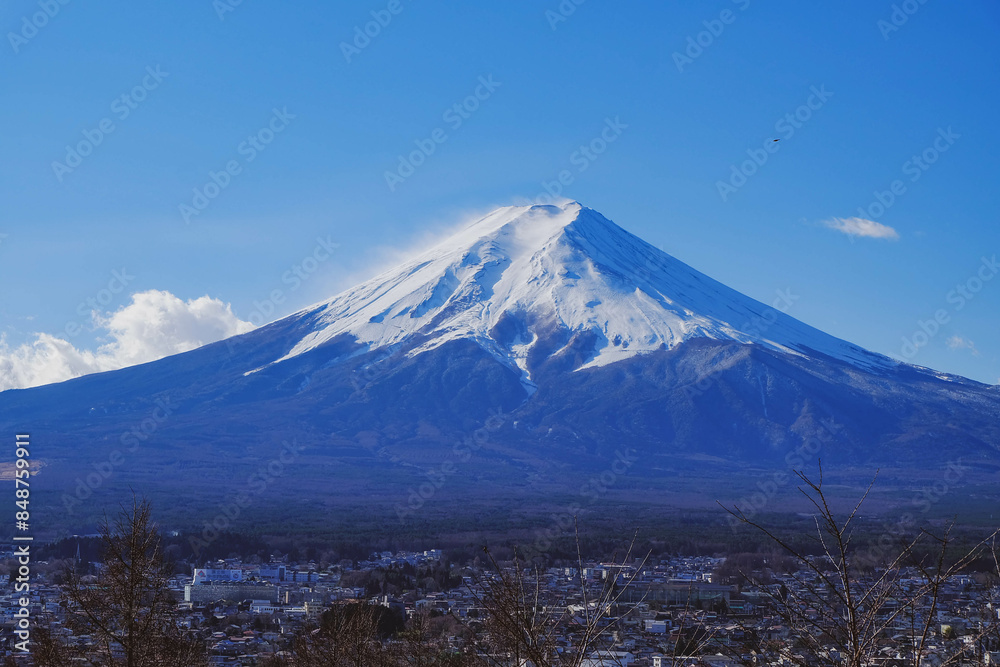 A distant view on Mt Fuji in Japan on a clear,The top parts of the volcano are covered with a layer of snow. A distant view on Mt Fuji in Japan on a clear,The top parts of the volcano are covered with a layer of snow.