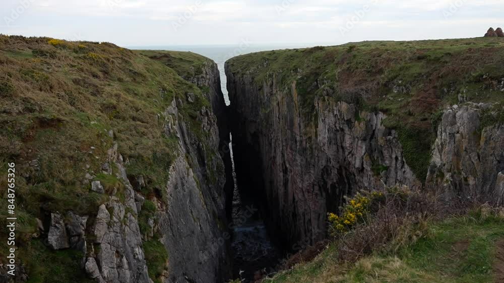 Water from the ocean entering into Huntsman's Leap through the limestone rock, Wales