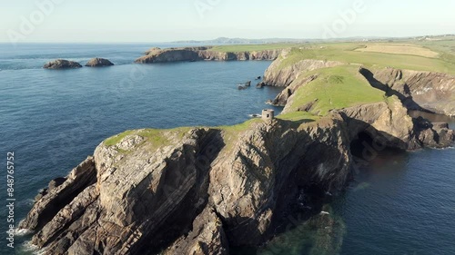 An aerial view of Abereiddi Tower in Pembrokeshire, South Wales, on a sunny evening with a clear blue sky. Flying over the tower towards the beach. photo