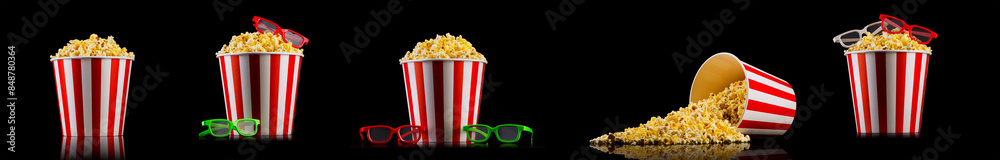 Scattered popcorn from paper striped bucket isolated on black background Scattered popcorn from paper striped bucket isolated on black background