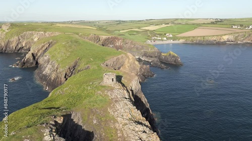 An aerial view of Abereiddi Tower in Pembrokeshire, South Wales, on a sunny evening with a clear blue sky. Circling right to left around the tower. photo