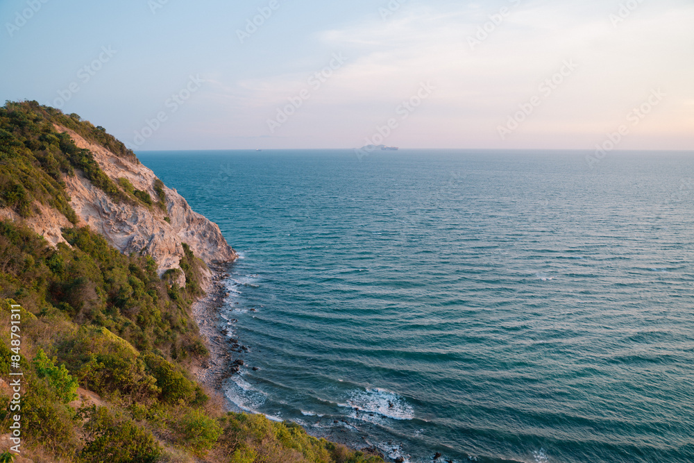 A beautiful ocean view with a rocky cliff in the background
