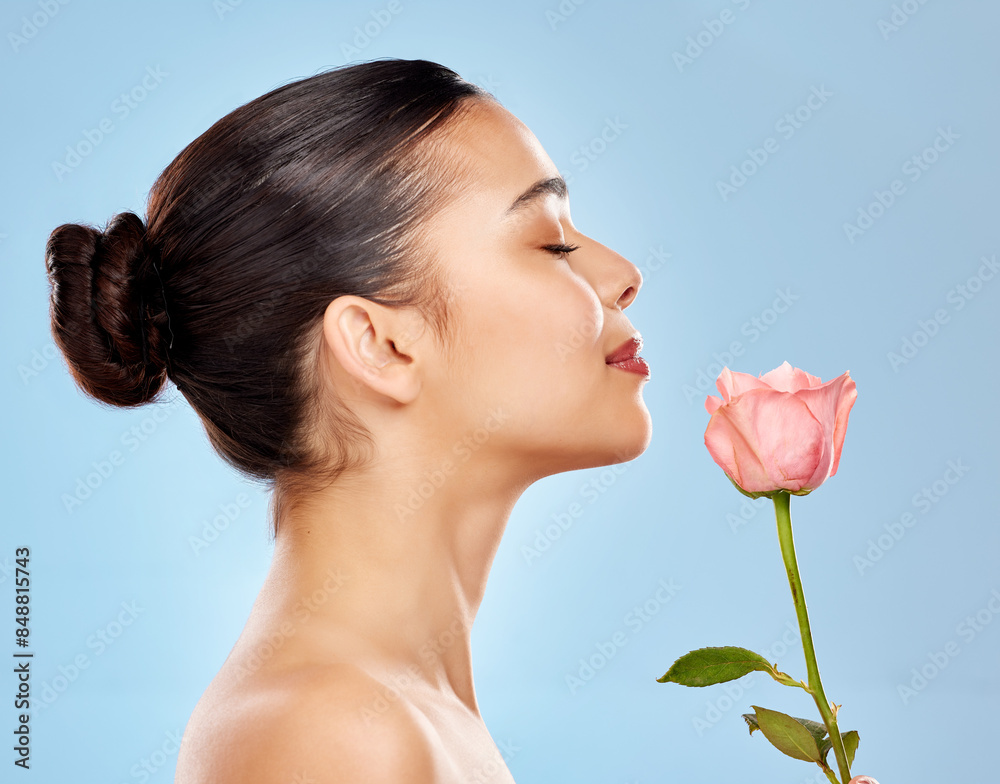 Woman, flower and beauty in studio or skincare, smooth and sustainable cosmetics on blue background. Female person, rose plant and organic facial treatment, dermatology and eco friendly in profile