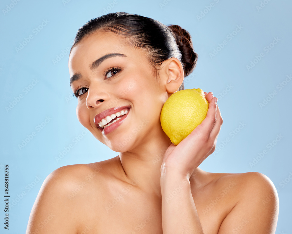 Woman, lemon and beauty portrait with vitamin c for skincare, natural glow and vegan nutrition for skin health in studio. Female person, dermatology and citrus fruit for detox by blue background Woman, lemon and beauty portrait with vitamin c for skincare, natural glow and vegan nutrition for skin health in studio. Female person, dermatology and citrus fruit for detox by blue background