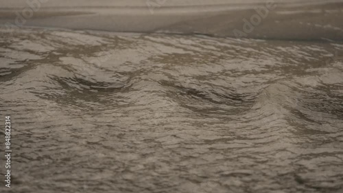 Ocean water flowing over sand in coastal beach photo