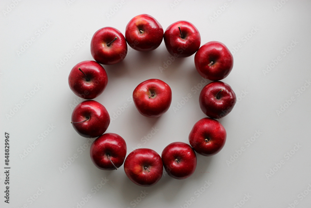 Perfect circle made with tightly fitted to each other red apples with one apple in center isolated on white Perfect circle made with tightly fitted to each other red apples with one apple in center isolated on white
