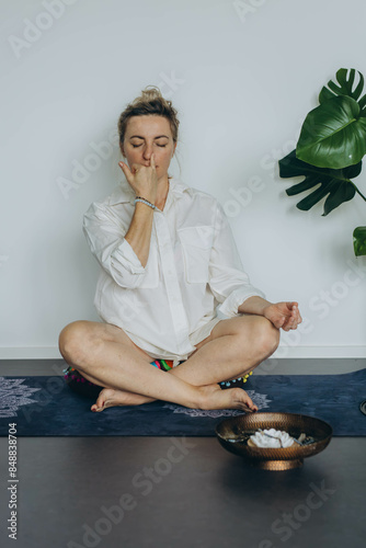Attractive young woman practing yoga stretching yoga at home.  photo