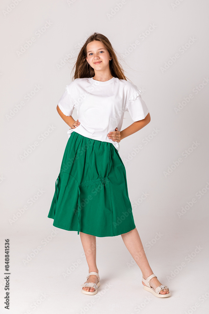 High fashion look. Glamor stylish beautiful young student girl model in summer green bright skirt and white shirt on white background. Copy space. Mock up High fashion look. Glamor stylish beautiful young student girl model in summer green bright skirt and white shirt on white background. Copy space. Mock up