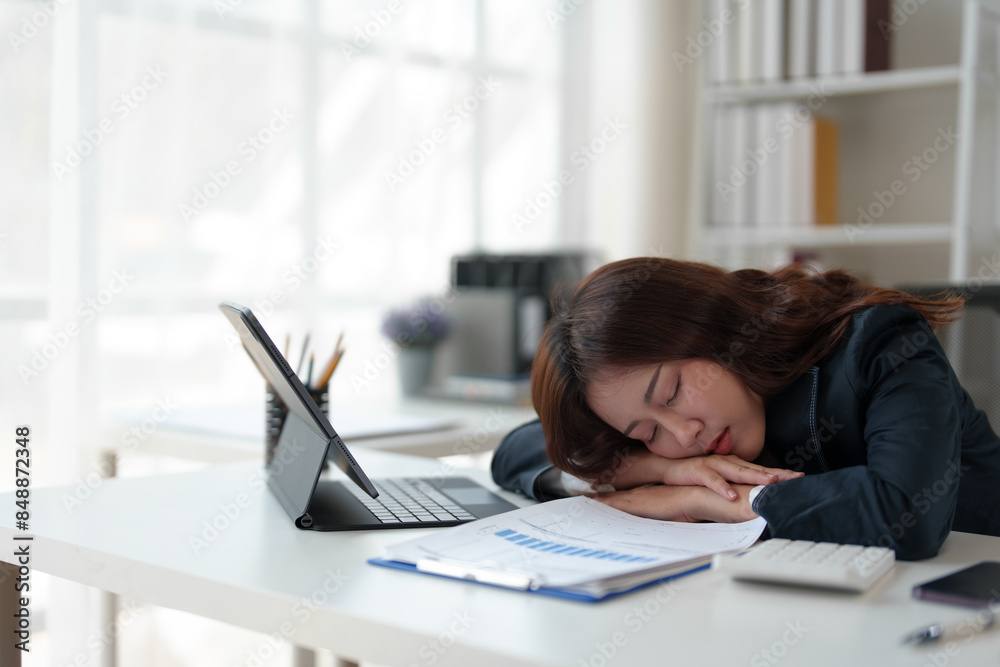 Tired businesswoman having a headache in modern office Creative woman working at office desk Casual female office worker Feeling a headache while working hard on a laptop computer. Tired businesswoman having a headache in modern office Creative woman working at office desk Casual female office worker Feeling a headache while working hard on a laptop computer.