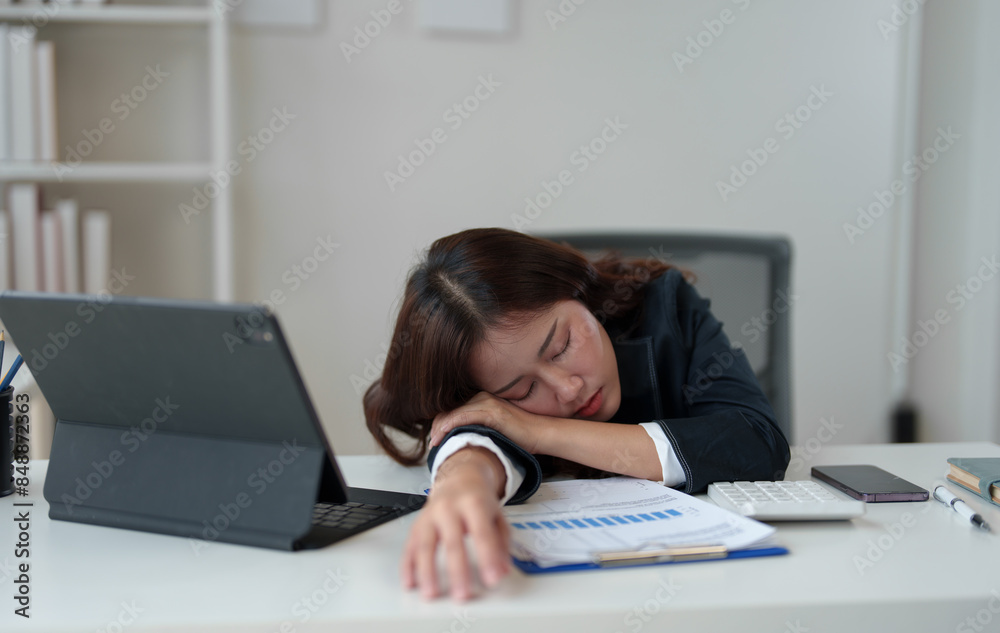 Tired businesswoman having a headache in modern office Creative woman working at office desk Casual female office worker Feeling a headache while working hard on a laptop computer. Tired businesswoman having a headache in modern office Creative woman working at office desk Casual female office worker Feeling a headache while working hard on a laptop computer.