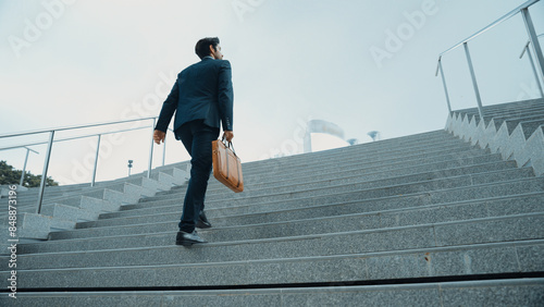Cuadro en lienzo Top view of smart business man walking up stairs with bag in the hand