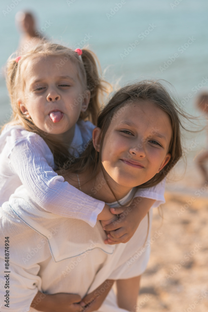 Fototapeta premium Sister's children relax, play and have fun on the sandy seashore