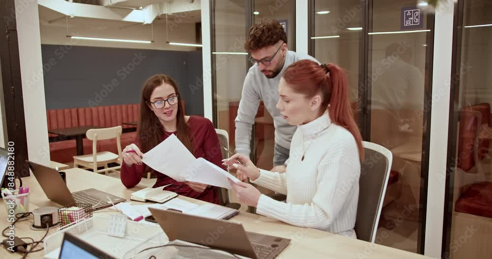 Colleagues discuss work-related documents in a brightly lit office, exuding teamwork and cooperation. Colleagues discuss work-related documents in a brightly lit office, exuding teamwork and cooperation.