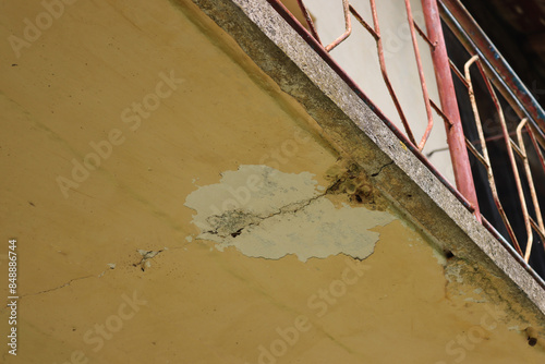 Bottom view of damaged balcony on a old house. Balcony with cracked concrete. Balcony repair, cracks in reinforced concrete structure photo