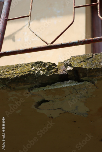 Bottom view of damaged balcony on a old house. Balcony with cracked concrete. Balcony repair, cracks in reinforced concrete structure photo