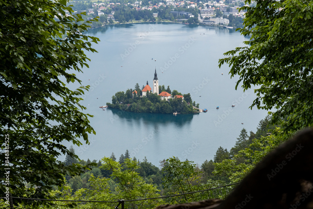 Obraz premium Panoramic view from Lake Bled, beauty heritage in Slovenia. Island with church and castle in the background create a dream setting. View from Ojstrica and Mala Osojnica with the heart-shaped bench.