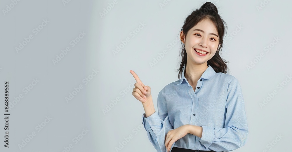 Confident Asian Business Woman Pointing Sideways in Blue Shirt and Black Skirt Confident Asian Business Woman Pointing Sideways in Blue Shirt and Black Skirt