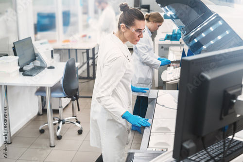 female doctor working in a modern equipped computer laboratory analyzes blood samples and genetic materials using special machines in a modern laboratory.	