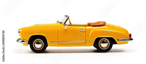 Yellow retro toy car cabriolet model on white backdrop shown in a side view with copy space image