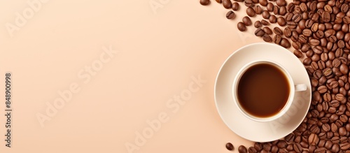 Beige plate with coffee cup and coffee capsules surrounded by raw beans creating a charming scene with copy space image photo