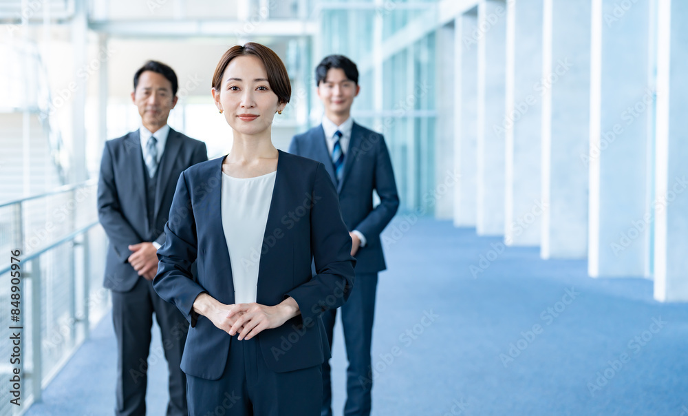 オフィスに立つスーツを着た3人 オフィスに立つスーツを着た3人