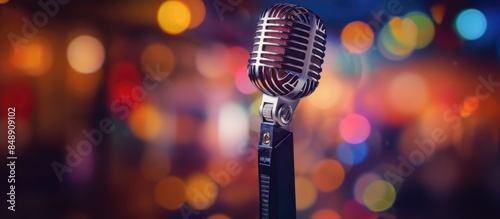Microphone against a backdrop of vibrant lights at a comedy night or a club bar with space available for inserting images. Copy space image. Place for adding text and design photo