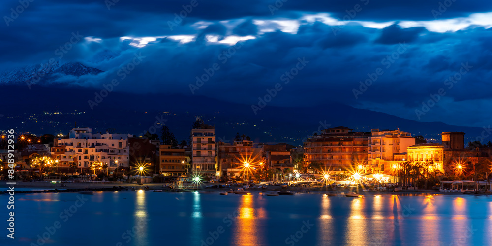 evening or night landscape of evening town coastline in golden lights and sea gulf with calm water and nice reflections with beautisul sunset sky on background evening or night landscape of evening town coastline in golden lights and sea gulf with calm water and nice reflections with beautisul sunset sky on background
