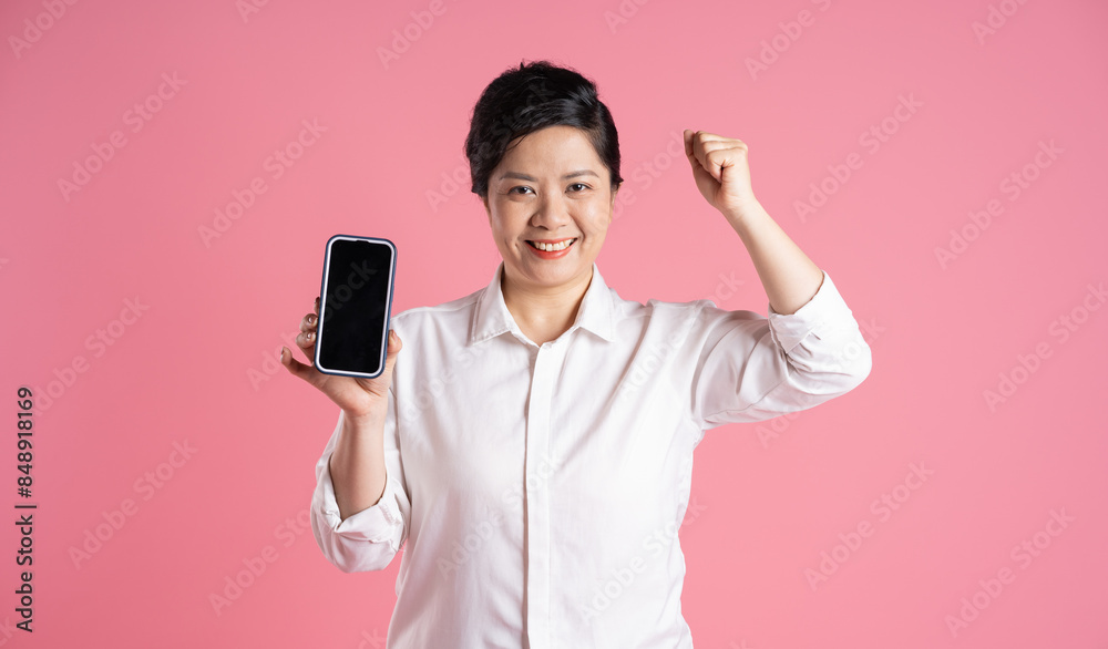 Image of older Asian businesswoman posing on pink background Image of older Asian businesswoman posing on pink background