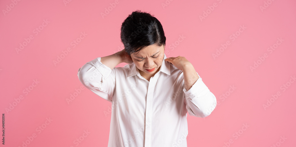 Image of older Asian businesswoman posing on pink background Image of older Asian businesswoman posing on pink background