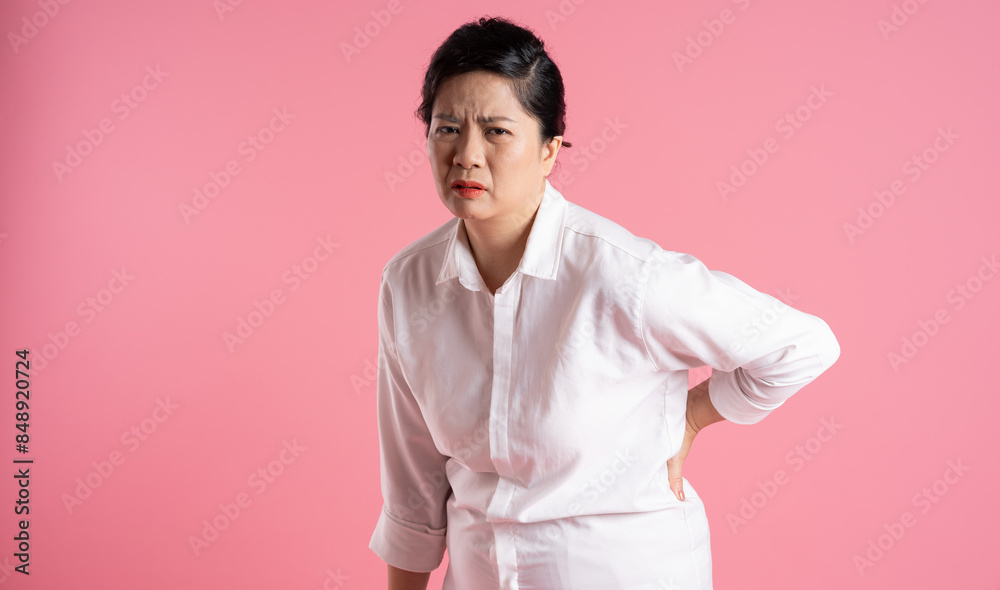 Obraz premium Image of older Asian businesswoman posing on pink background