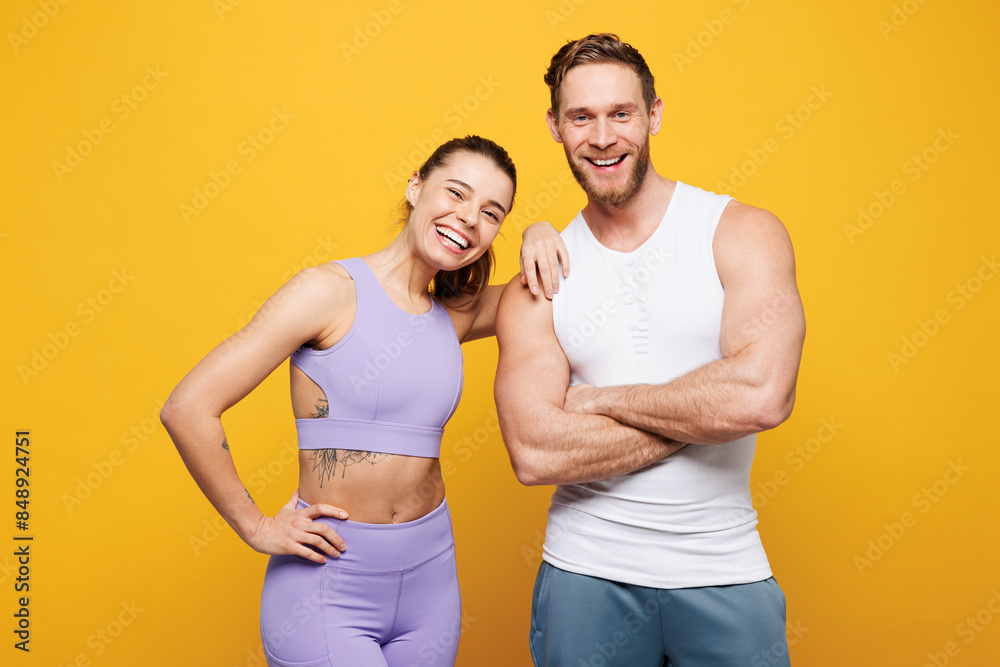 Young smiling happy fun fitness trainer instructor sporty two man woman wears blue clothes spend time in home gym put hand on shoulder isolated on plain yellow background. Workout sport fit concept. Young smiling happy fun fitness trainer instructor sporty two man woman wears blue clothes spend time in home gym put hand on shoulder isolated on plain yellow background. Workout sport fit concept.