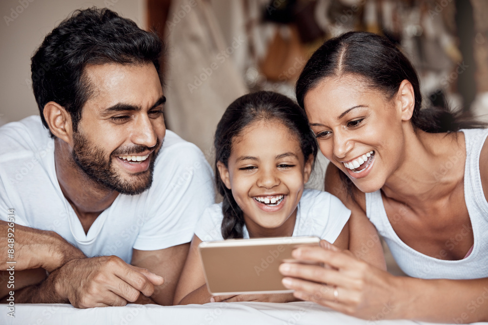 Happy, phone and streaming with family on bed together in home for entertainment or to relax. Love. movie or smile with mother, father and daughter watching video in bedroom of apartment for bonding Happy, phone and streaming with family on bed together in home for entertainment or to relax. Love. movie or smile with mother, father and daughter watching video in bedroom of apartment for bonding