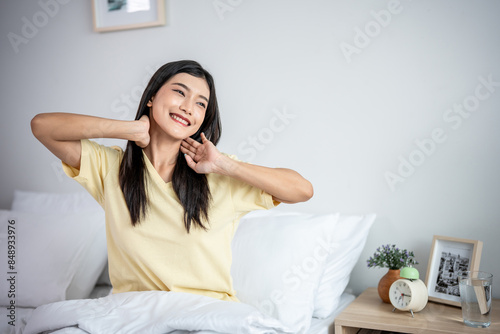 Asian young beautiful woman getting up from sleep on bed in the morning. 