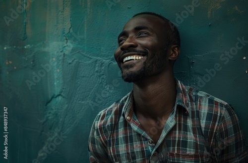 Joyful African Man Laughing Against Textured Blue Wall