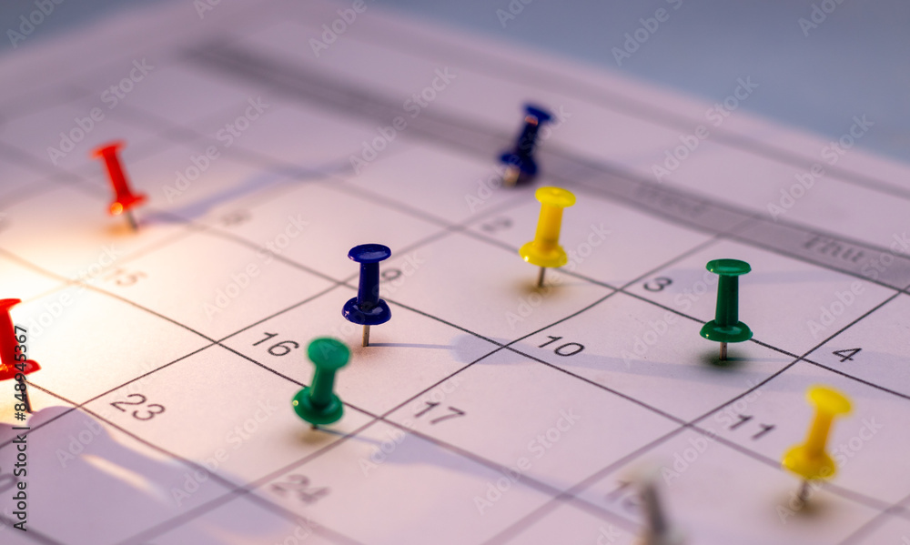 Side angle of Colorful Push pin in calendar. Calendar page pinned in calender on date, business meeting schedule or travel planning concept. and reminder concept. Calendar appointment Side angle of Colorful Push pin in calendar. Calendar page pinned in calender on date, business meeting schedule or travel planning concept. and reminder concept. Calendar appointment