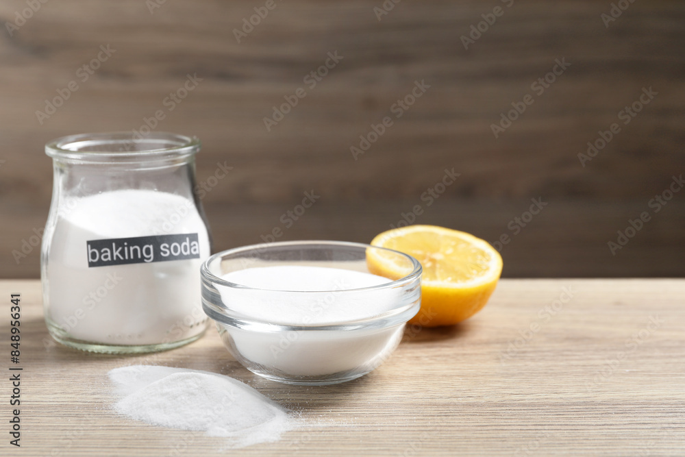 Baking soda and lemon on wooden table, space for text Baking soda and lemon on wooden table, space for text