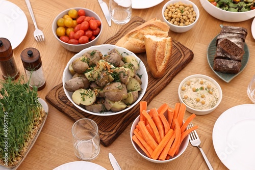 Healthy vegetarian food, glasses, cutlery and plates on wooden table