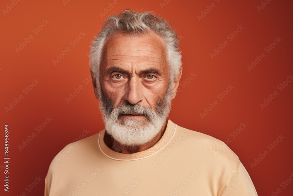 Obraz premium Portrait of a content man in his 70s sporting a long-sleeved thermal undershirt in front of solid color backdrop