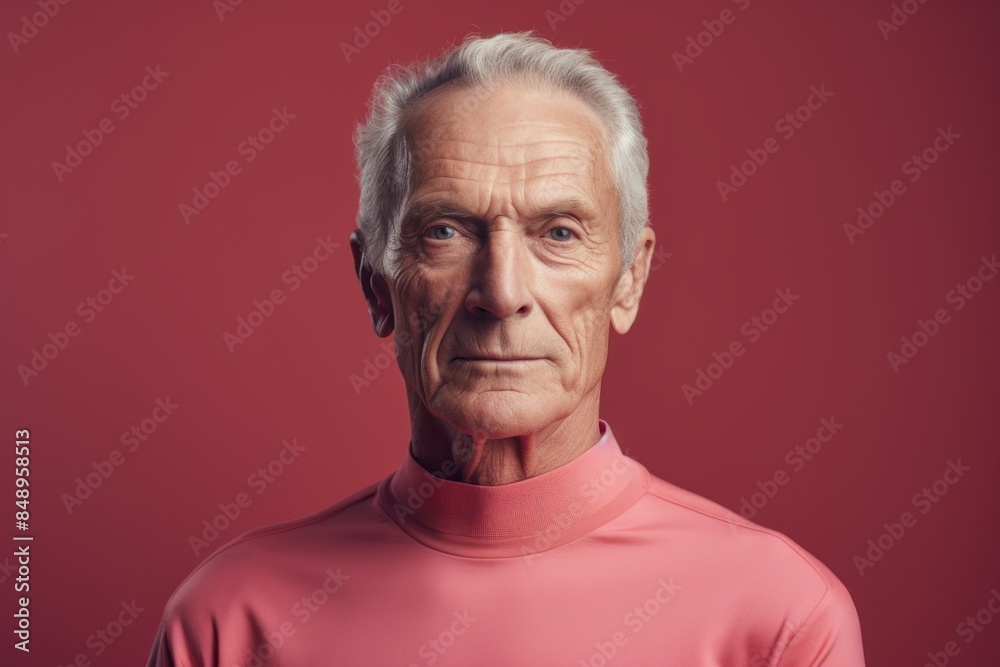 Obraz premium Portrait of a content man in his 70s sporting a long-sleeved thermal undershirt in front of solid color backdrop