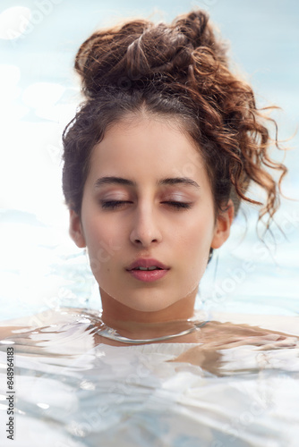 Skincare and Wellness close up portrait of a young woman with brown hair and beautiful skin in the water. Closed Eyes.  