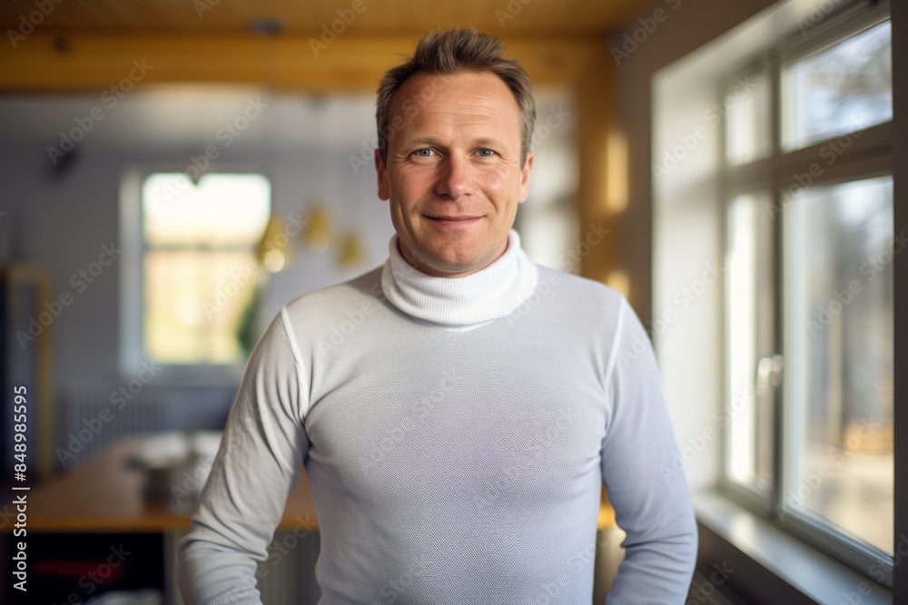 Portrait of a jovial man in his 40s sporting a long-sleeved thermal undershirt over scandinavian-style interior background Portrait of a jovial man in his 40s sporting a long-sleeved thermal undershirt over scandinavian-style interior background