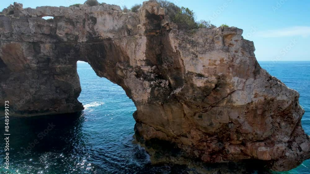 4K Aerial Drone video of a unique rock formation with an arch separated from the cliffs with turquoise clear blue water and beach nearby. Es Pontas, Mallorca 4K Aerial Drone video of a unique rock formation with an arch separated from the cliffs with turquoise clear blue water and beach nearby. Es Pontas, Mallorca