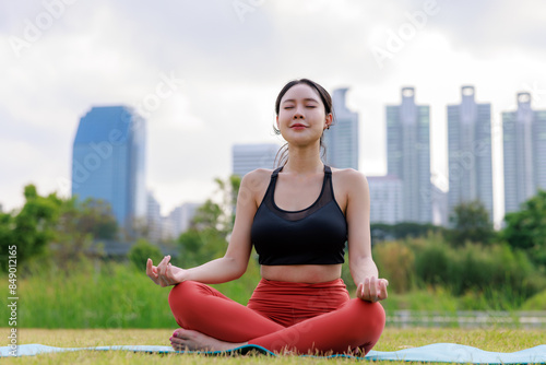 Young woman exercises and yoga on a lawn of a city park, activities leisure holidays on weekend of life urban society concept. © SHUTTER DIN