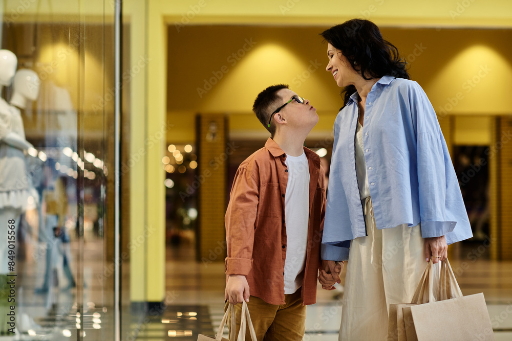 A mother and her son with Down syndrome walk through a shopping mall, enjoying a day out together. A mother and her son with Down syndrome walk through a shopping mall, enjoying a day out together.
