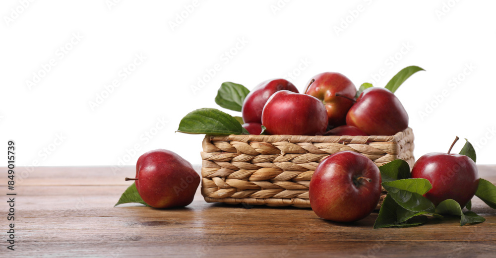 Fresh red apples and leaves in basket on wooden table against white background. Space for text Fresh red apples and leaves in basket on wooden table against white background. Space for text