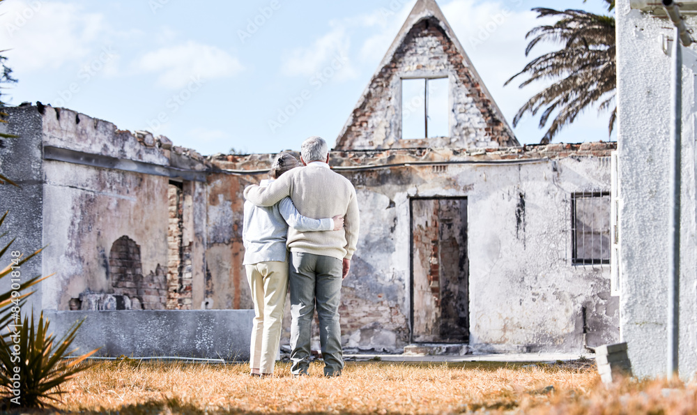 Senior man, woman and disaster in home or building with hug and insurance for real estate or accident. Backyard, comfort and fire risk or problem with destruction and sad for loss, homeless or damage Senior man, woman and disaster in home or building with hug and insurance for real estate or accident. Backyard, comfort and fire risk or problem with destruction and sad for loss, homeless or damage